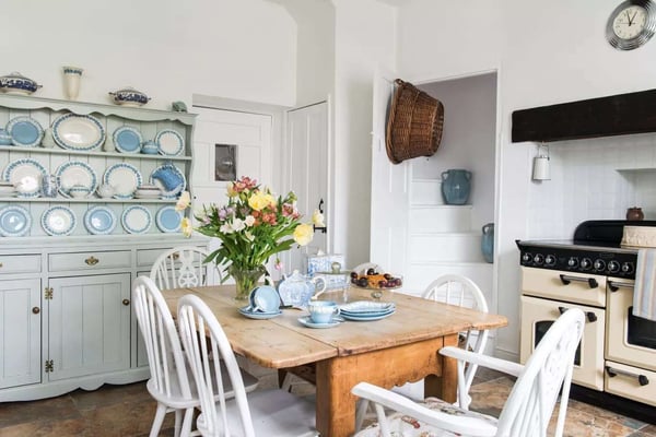 white and blue dining room kitchen area with traditional white arger stove and patterned plates