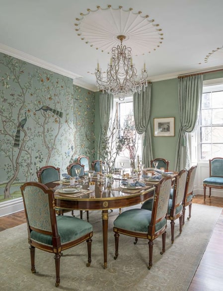 sea foam green dining room with patterned coloured wallpaper and matching dining chairs with chandelier overhead