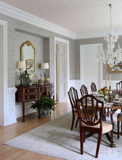 classy dining room with light grey walls, dark wooden dining table and chandelier