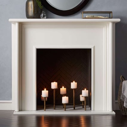 white false fireplace with candles clustered in the middle