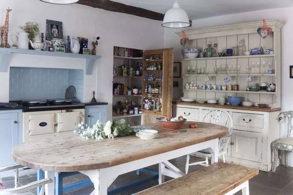 rustic wood dining table in cream and blue themed kitchen and dining area