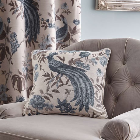 Cushion with blue and purple peacock design that matches the curtains