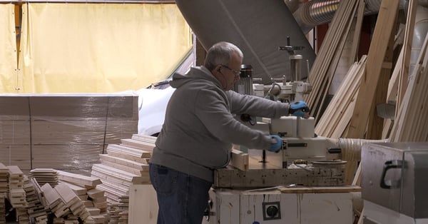 Craftsmen working on machinery during the bed manufacturing process